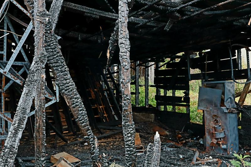 Charred roof beams and fire debris inside a burnt building